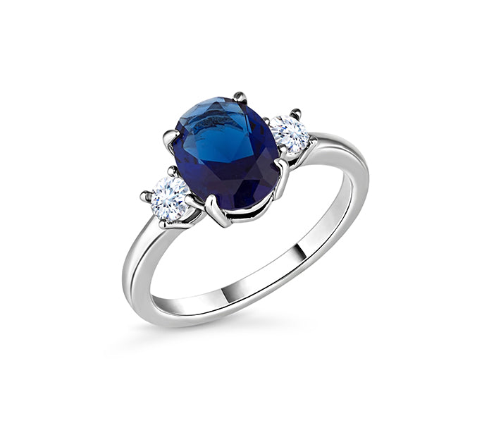 Oval cut blue ring with clear side stones in rhodi